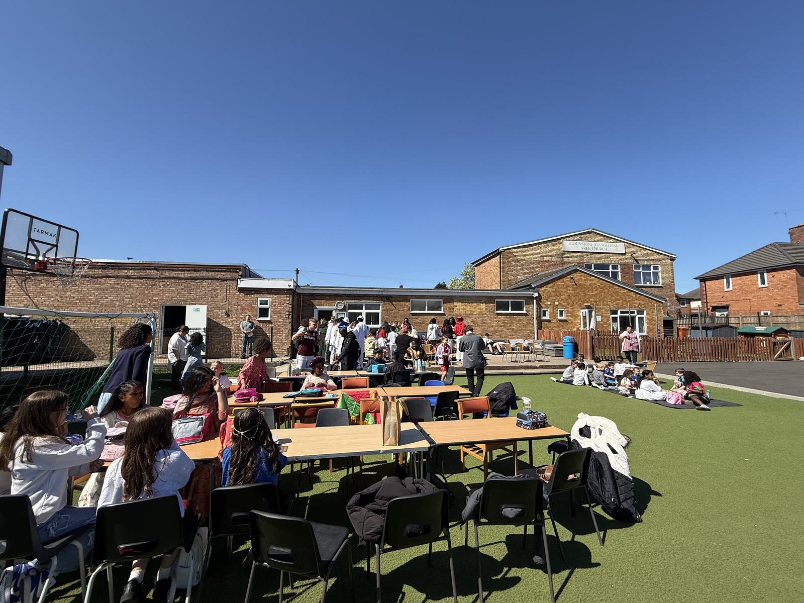 Pupils eating lunch outside on the all-weather pitch